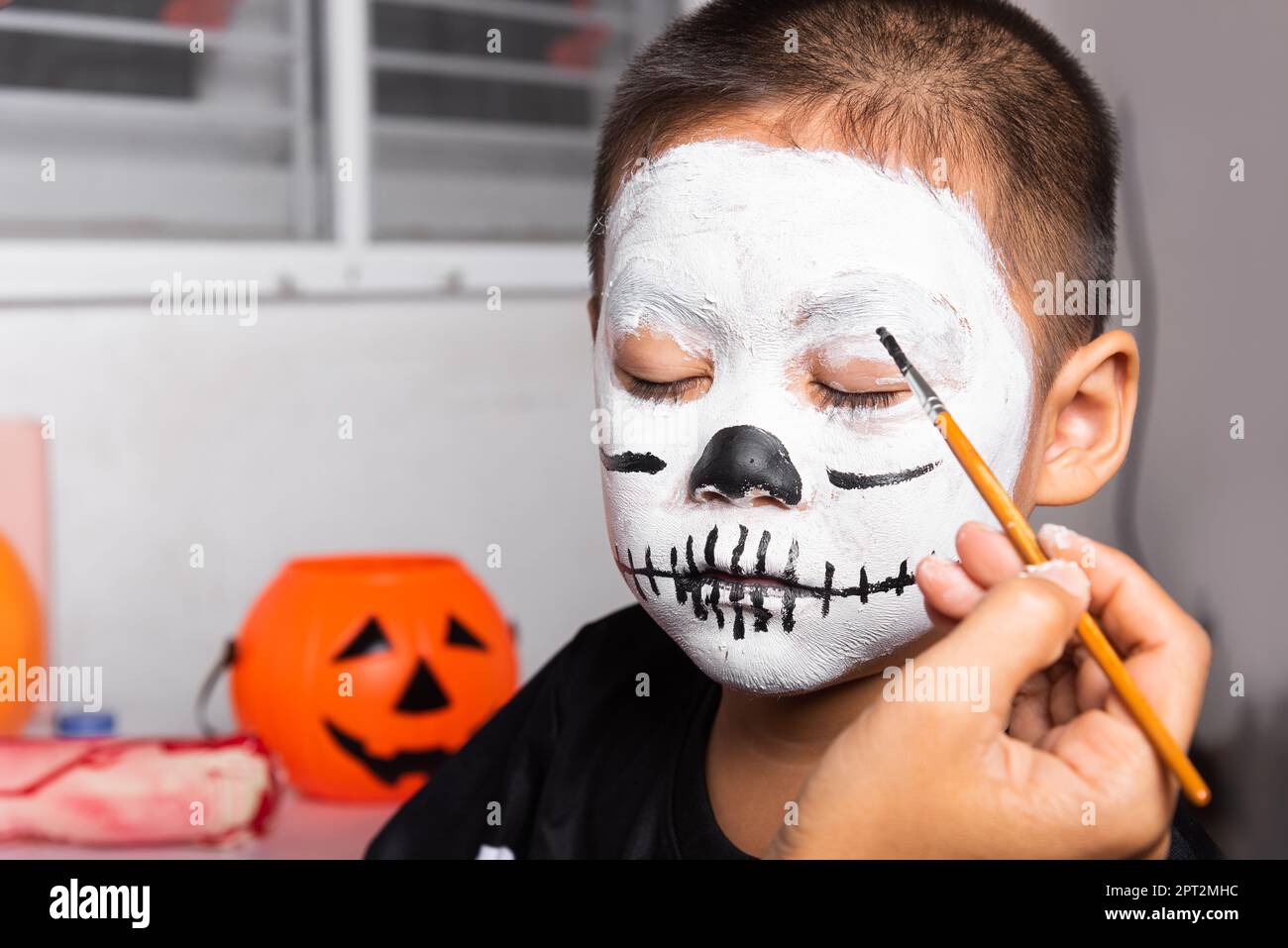 Asian mother and kid son getting makeup halloween face painting 