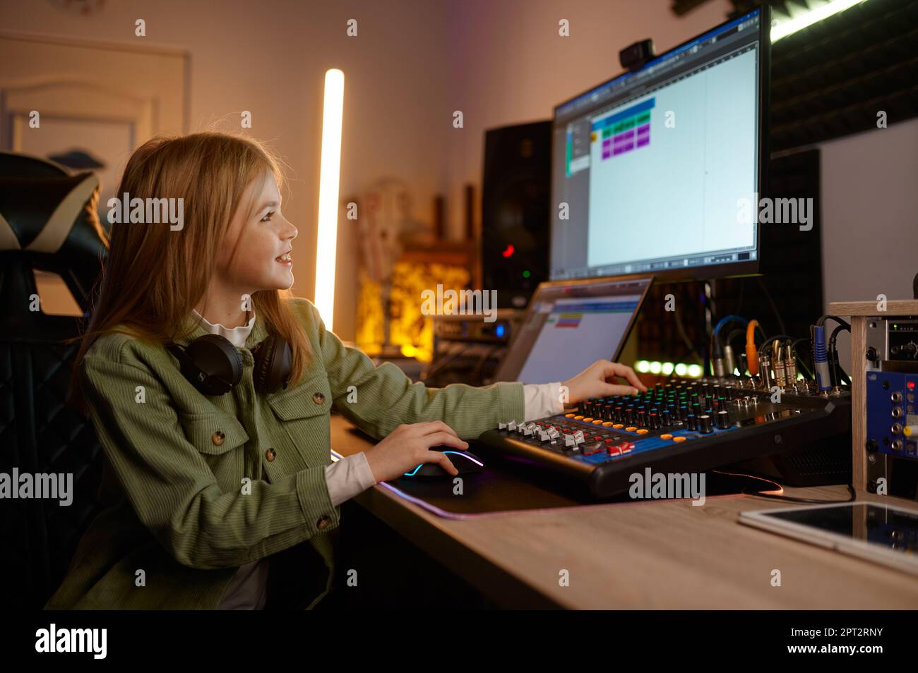 Young sound producer preteen girl child working on audio mixing board ...