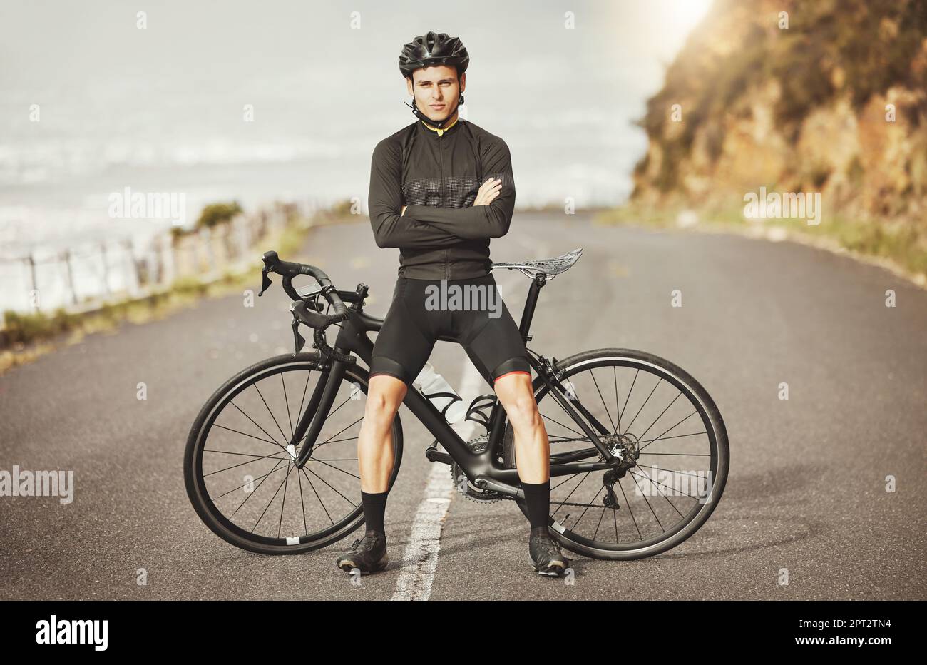 Man, cycling and mountain bike with arms crossed for sports exercise, training and fitness in nature. Portrait of a confident male professional cyclis Stock Photo