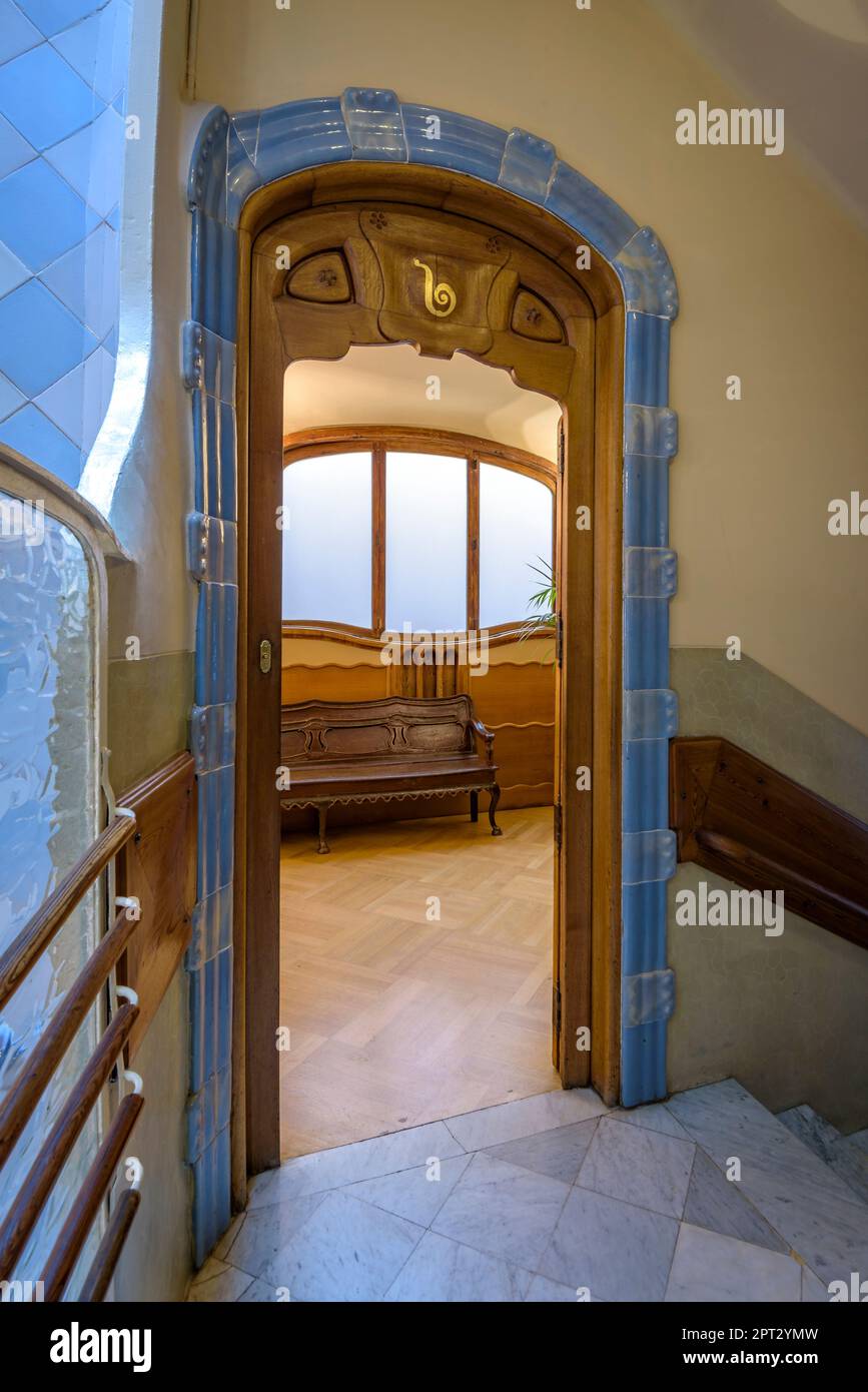 Wooden door and bench at the entrance of a flat decorated with modernist furniture in Casa Batlló (Barcelona, Catalonia, Spain) Stock Photo