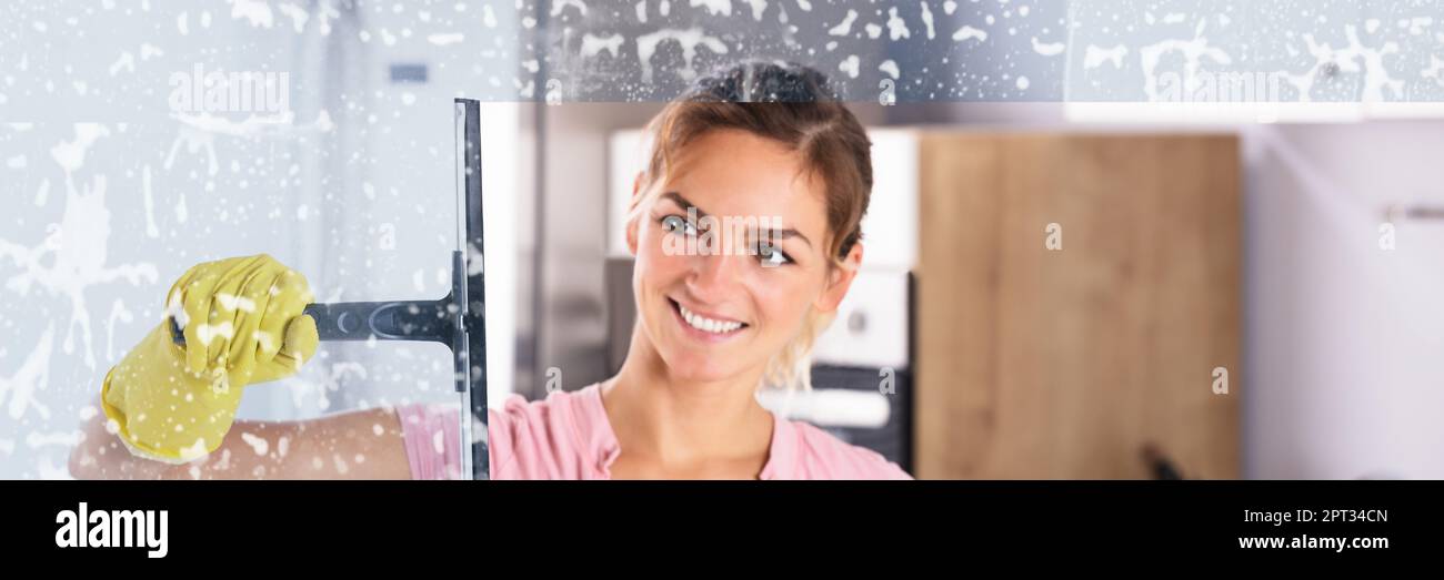 Janitor Cleaning Office Glass. Happy Smiling Woman Stock Photo