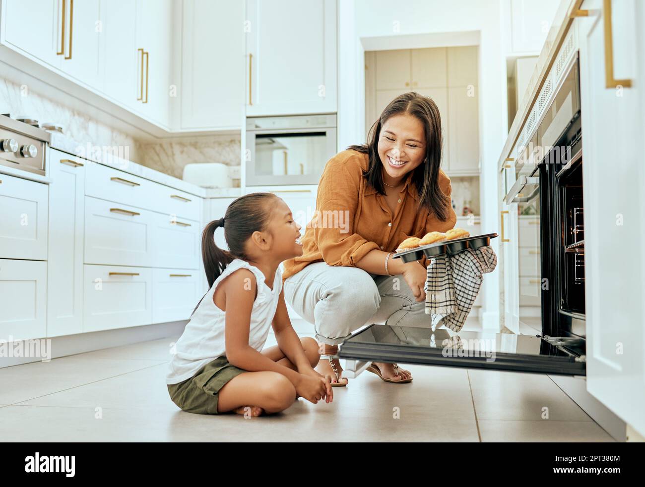 Asian, mom and girl in kitchen at oven, baking and cupcakes with stove