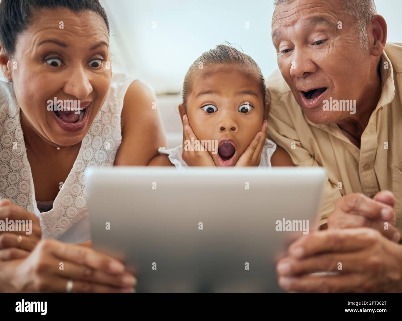 Tablet, family and shocked face child look at video online bonding ...