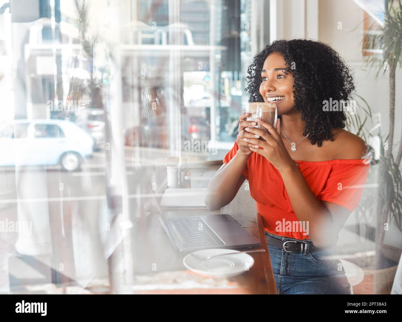 Coffee shop, thinking and happy black woman in cafe drinking espresso or cappuccino while doing remote work on laptop. Freelance female with drink for Stock Photo