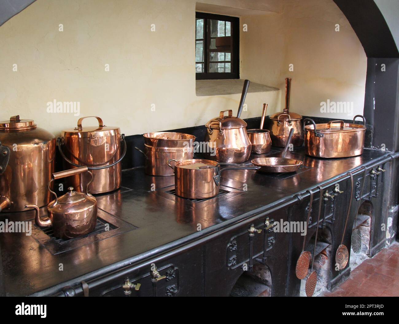 Copper Saucepans on a Large Vintage Cooking Range. Stock Photo