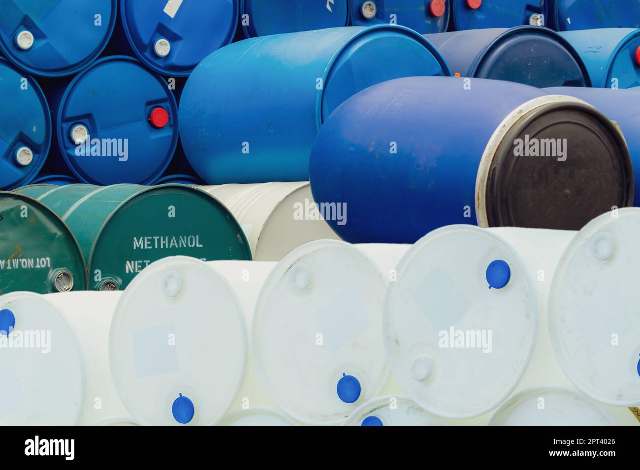Old chemical barrels. Stack of methanol or methyl alcohol drum. Steel chemical tank. Toxic waste. Plastic and steel chemical barrels. Industrial waste Stock Photo