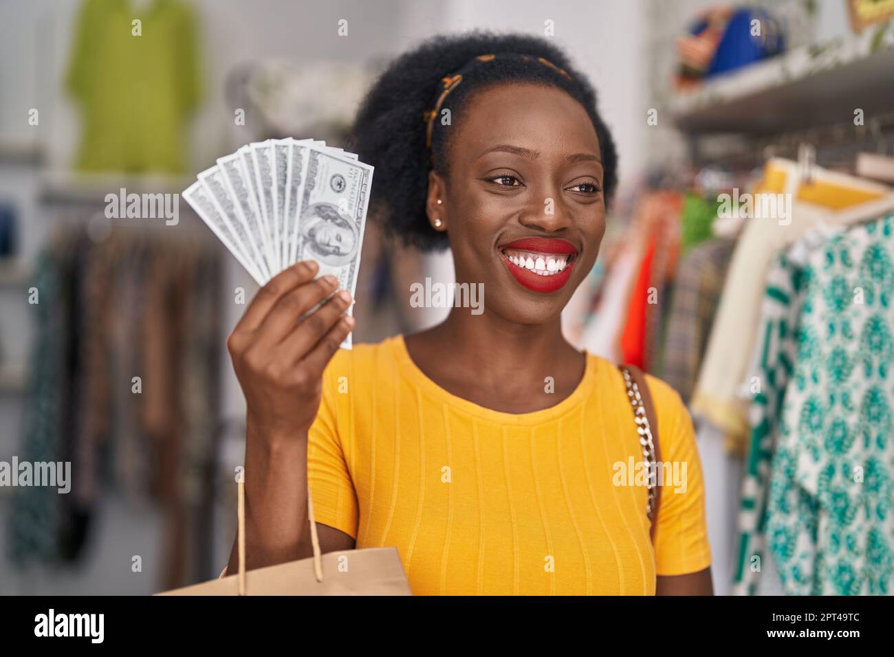 African american woman customer holding shopping bags and dollars at