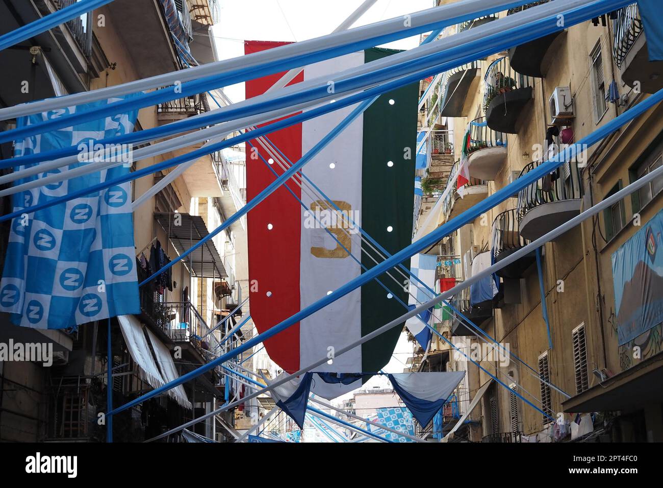 Napoli, Italy. 27th Apr, 2023. Flags and banners in honor of Napoli displayed in the alleys of Forcella, during the preparations for the celebration of the victory of the Italian Serie A championship and the third scudetto 'shield with the colors of the Italian flag, which is worn on the game uniform by the team that won the championship in the previous season'. Credit: Vincenzo Izzo/Alamy Live News Stock Photo