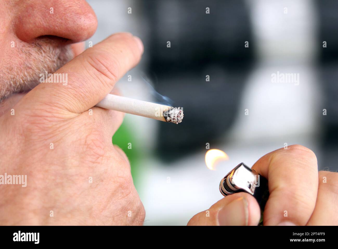 Mann zündet sich eine Zigarette an Stock Photo