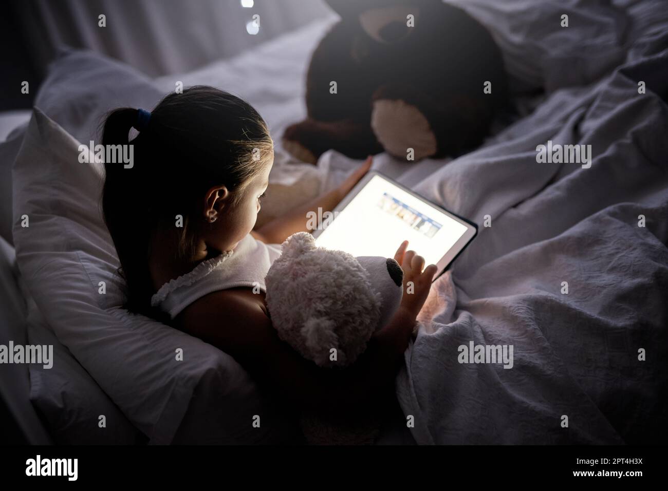 Looks like shes glued to that screen. an adorable little girl using a