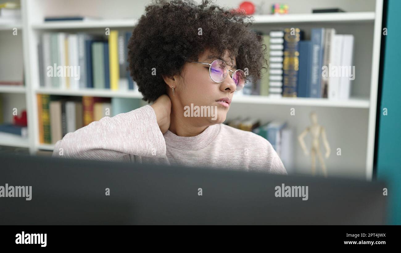 Young african american woman student using computer stressed at ...