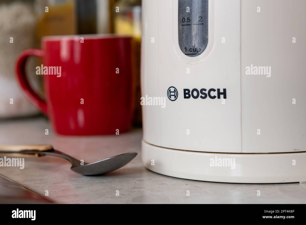 London. UK- 04.19.2023. A Bosch kettle with a tea spoon and red cup. Stock Photo