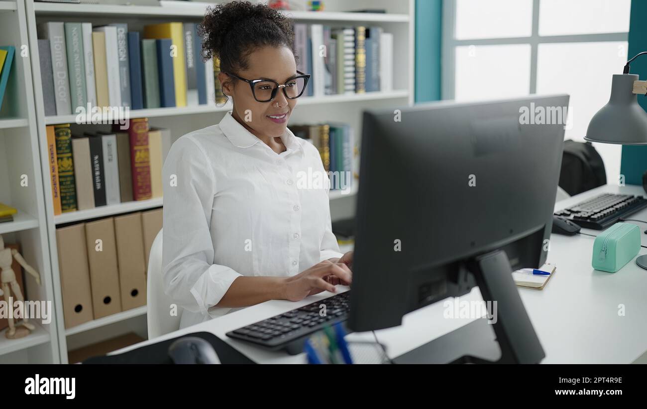 African american woman student using computer studying at library ...