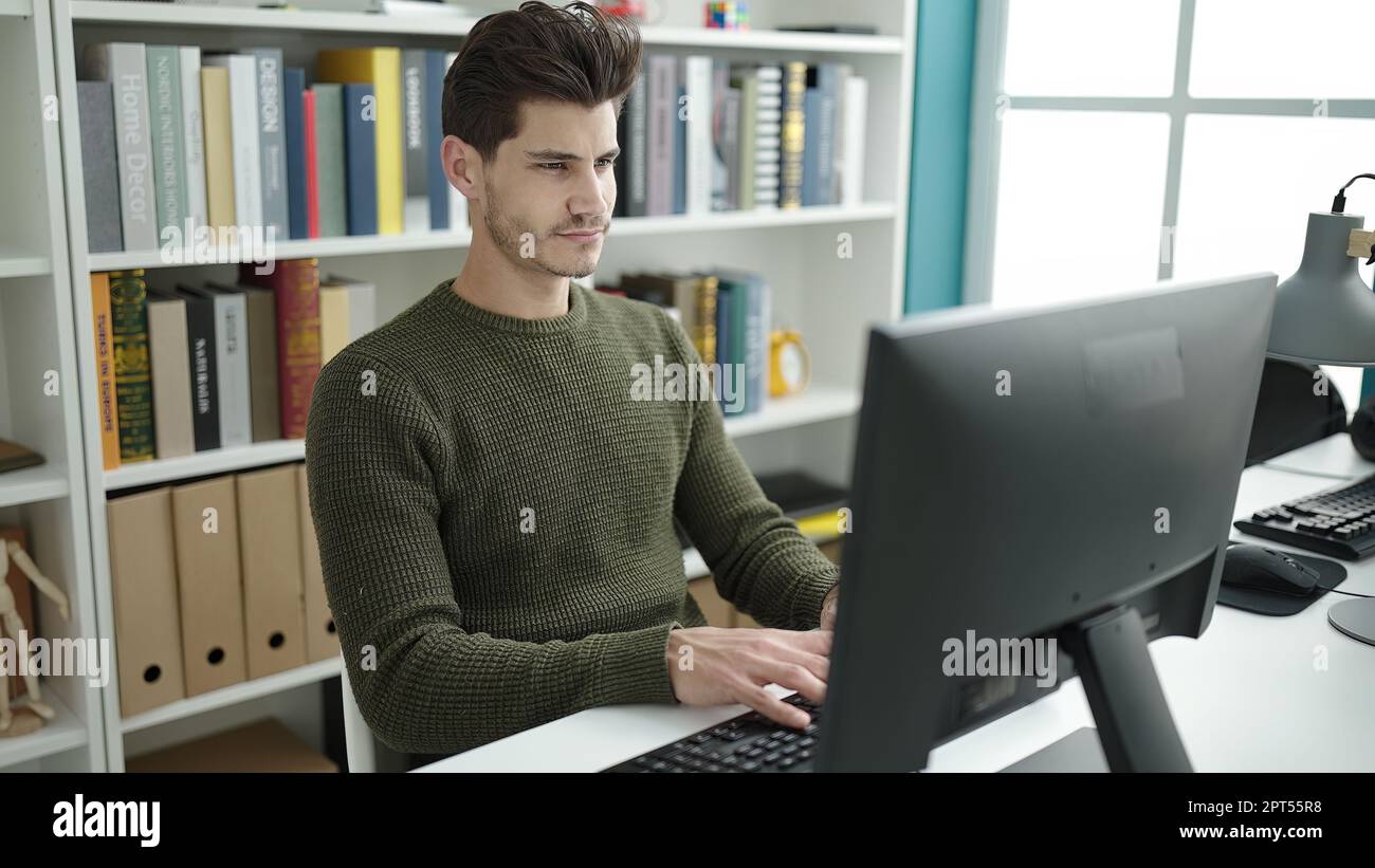 Hispanic Man Using Computer Young hispanic man student using computer studying at library ...