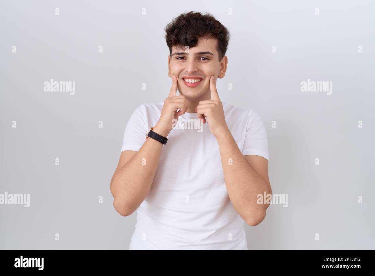 Young non binary man wearing casual white t shirt smiling with open ...