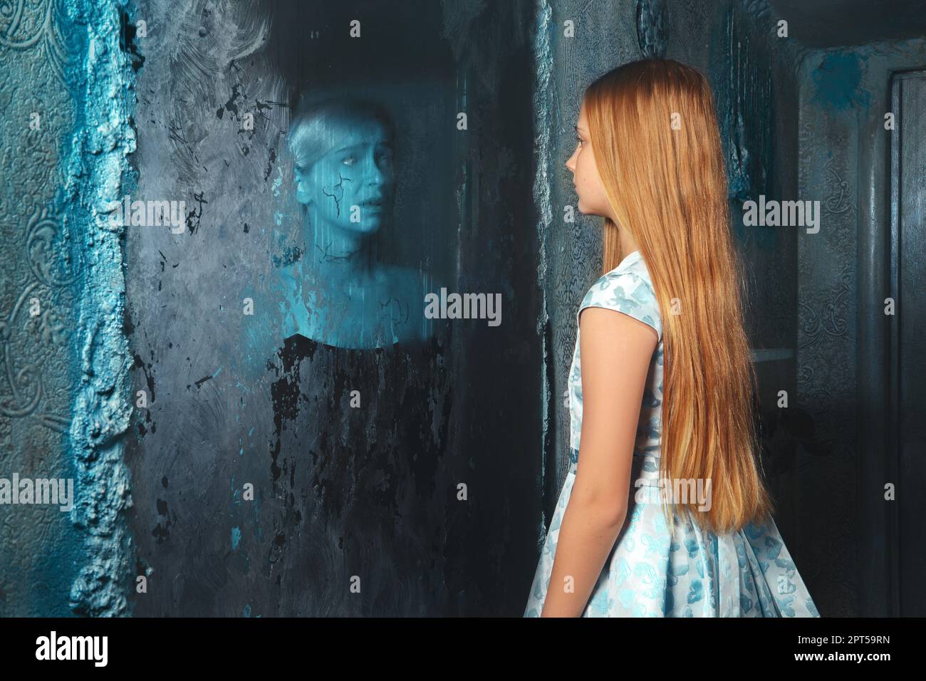 Lunatic young girl looking in the mirror and seeing in reflection a ghost of murdered woman Stock Photo