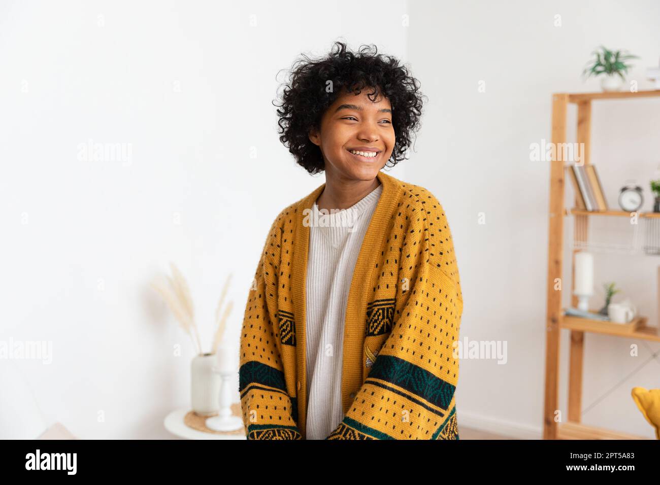 Beautiful african american girl with afro hairstyle smiling at home ...
