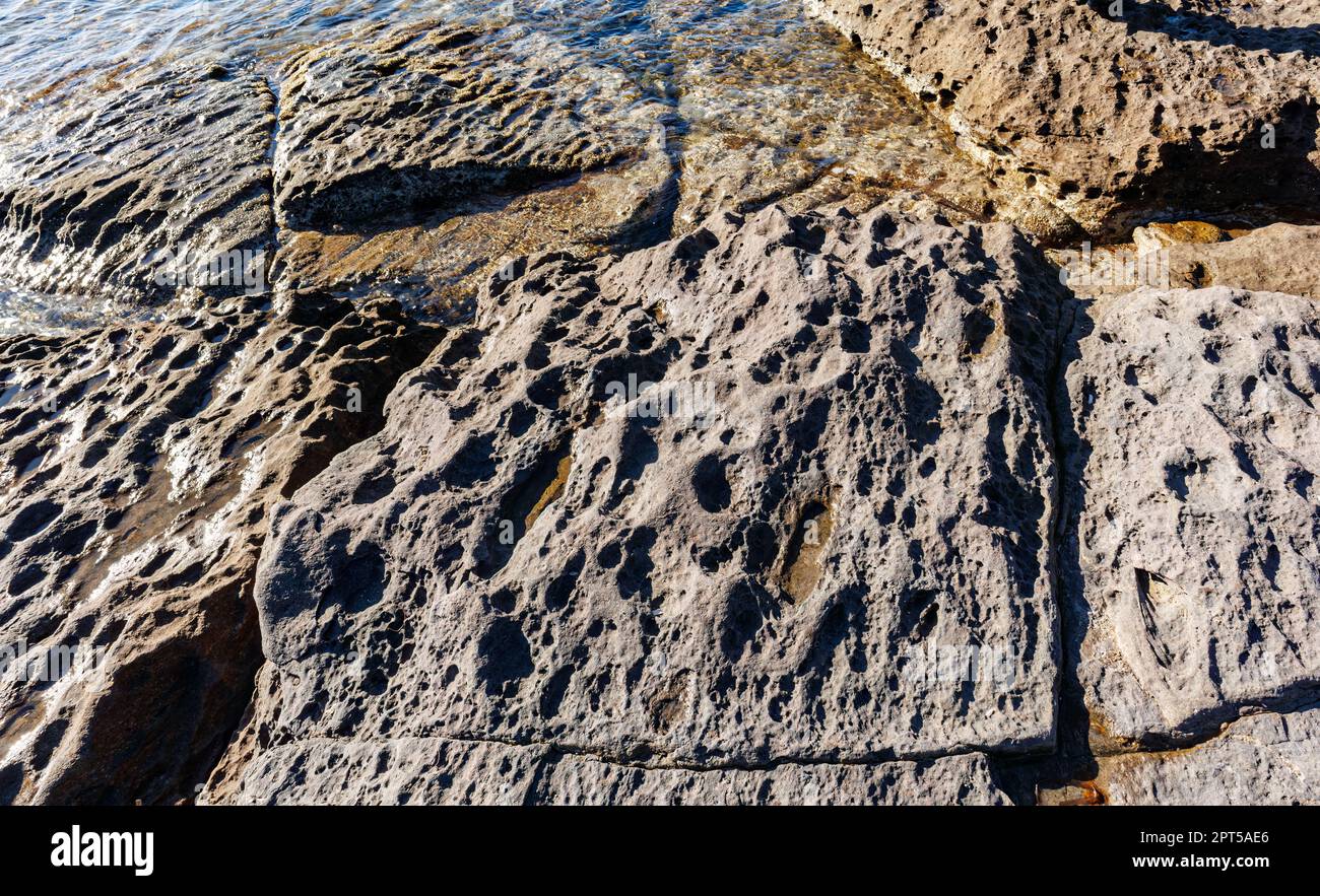 unusual rock formations of the volcanic cliff on Cala Sapone beach ...