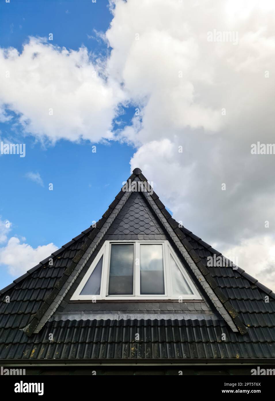Open roof window in velux style with black roof tiles Stock Photo