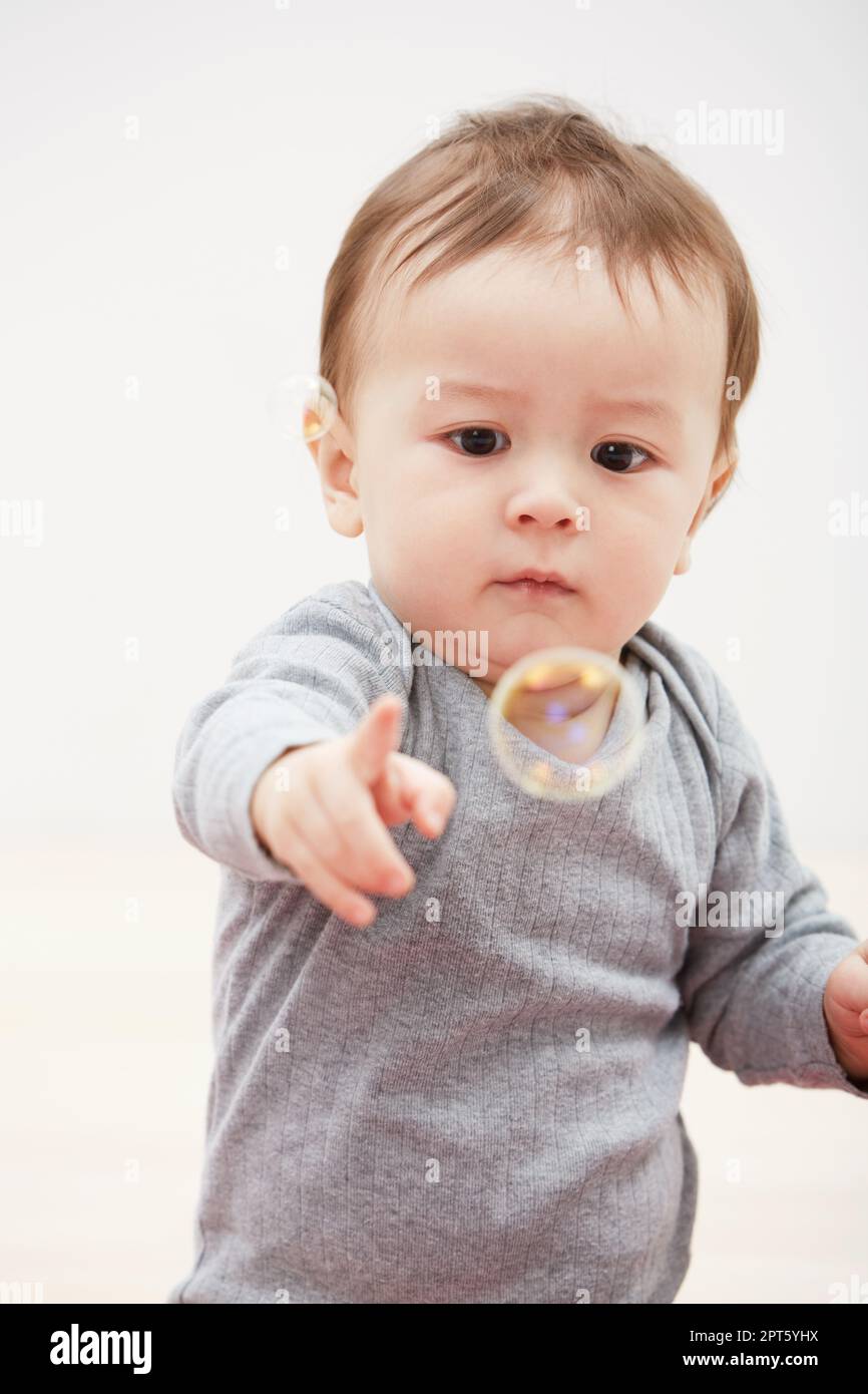Curious about everything. an adorable baby boy trying to touch bubbles