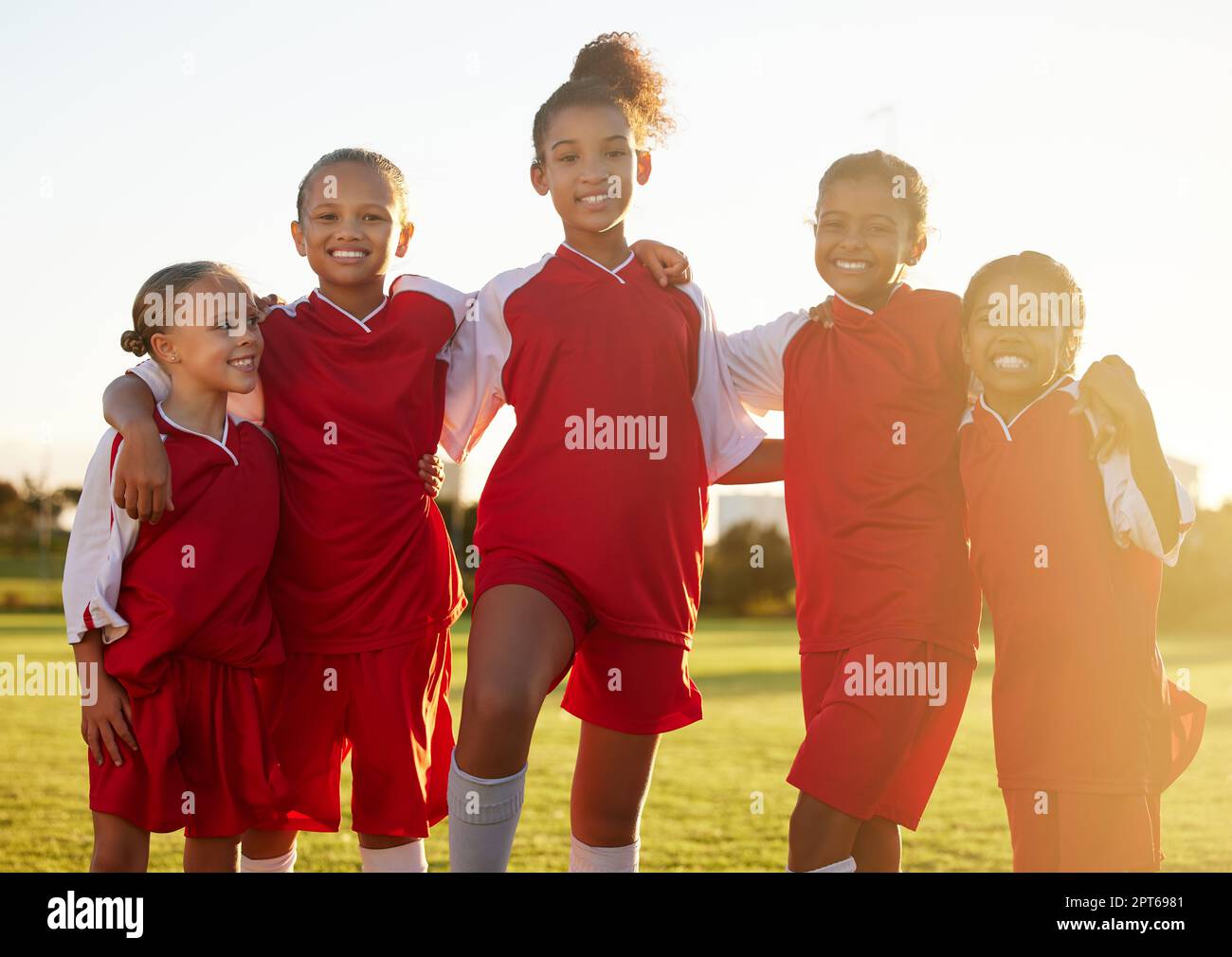 Girl team, kids group portrait on soccer field and happy girls together