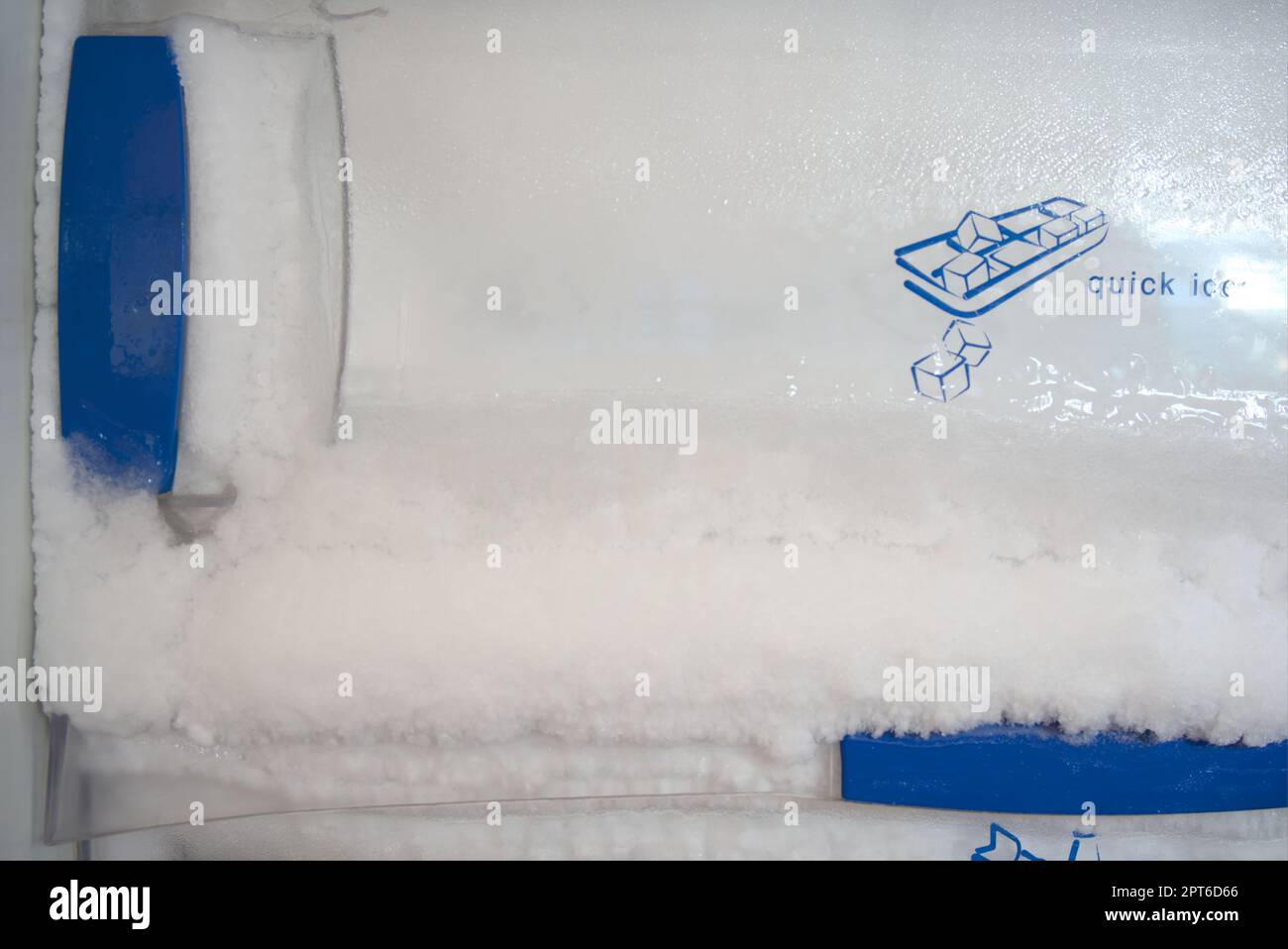 Frost build up in freezer. Harden ice pushing out of freezer door. Stock Photo