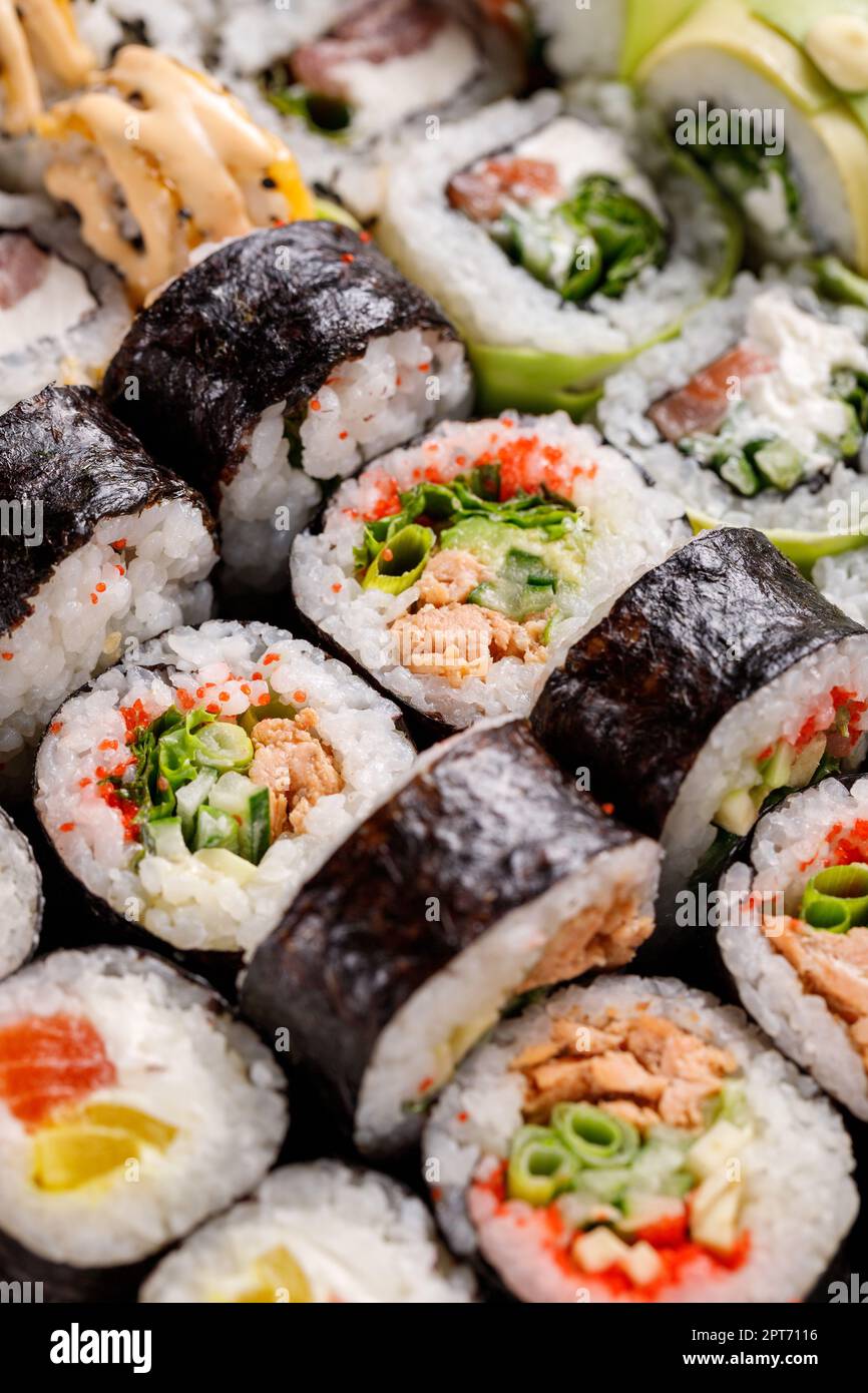 Oriental traditional seafood. Close up of original sushi rolls with different fillings standing