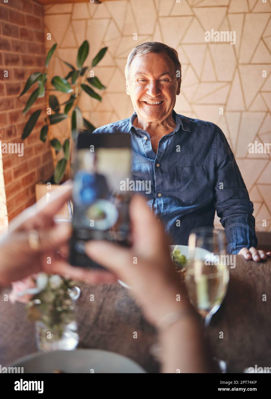 Senior man, phone and smile for picture on travel, vacation or restaurant experience while excited and happy at table. Elderly male tourist smiling fo Stock Photo