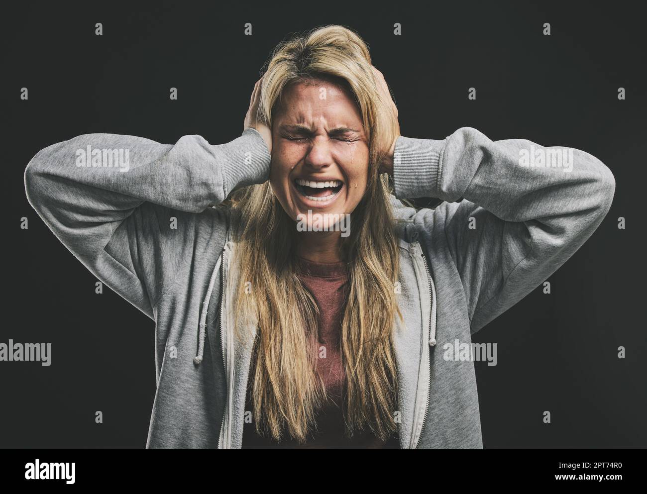 Stress, screaming or crying woman with hands over ears on black