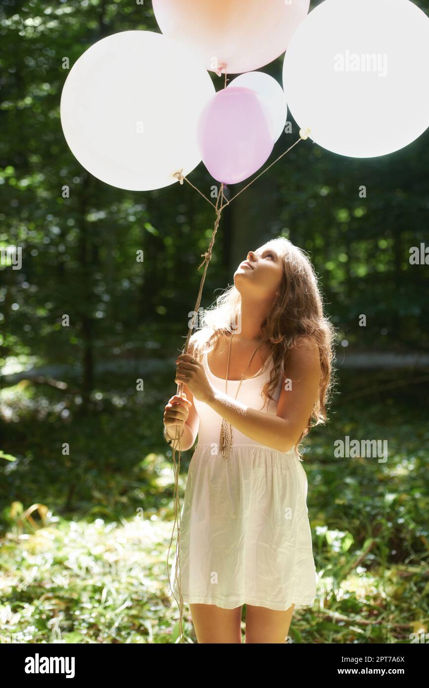 Feeling childlike. A pretty young woman holding a bunch of ...