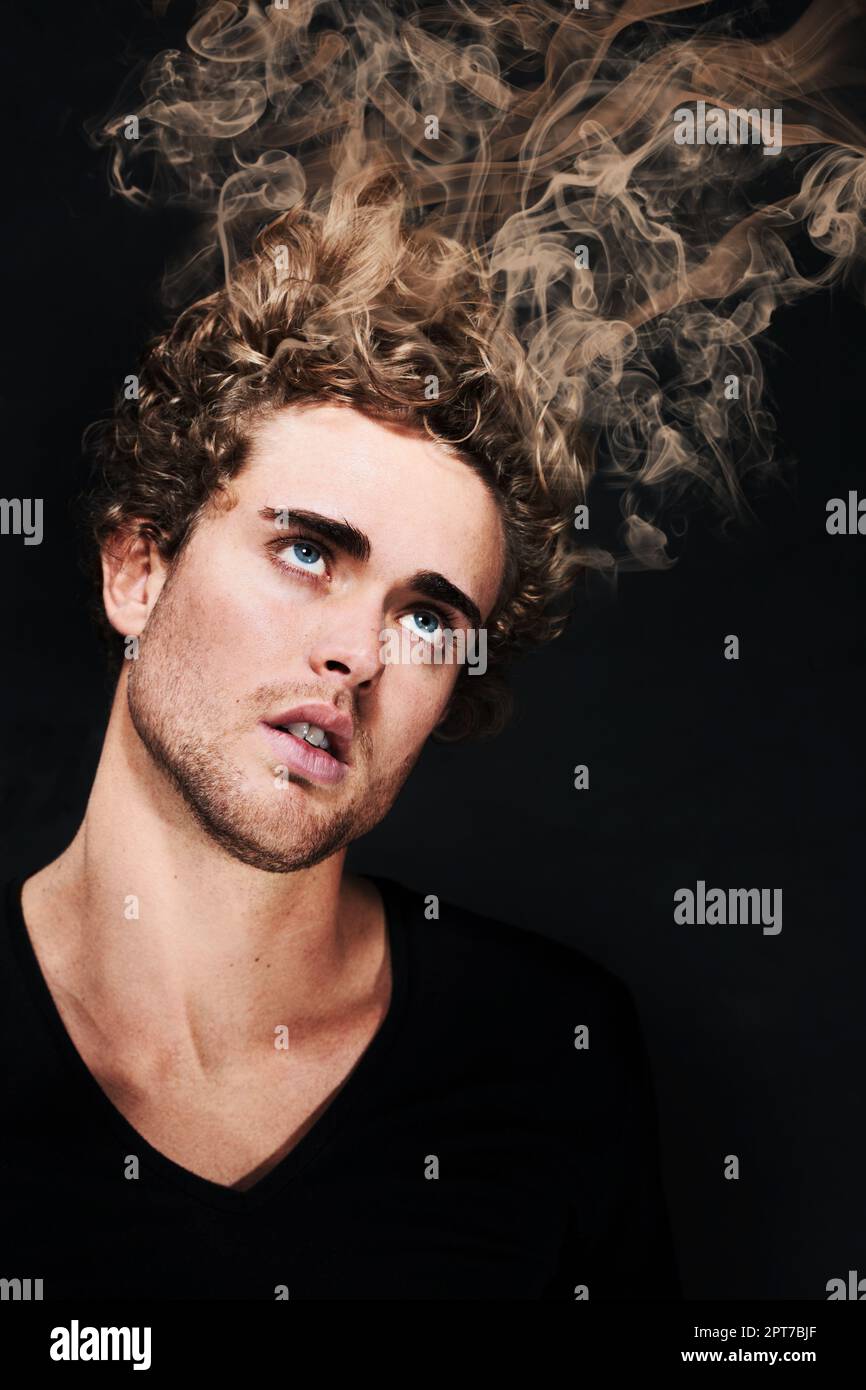 Going up in smoke. An intoxicated man looking up as his hair smokes