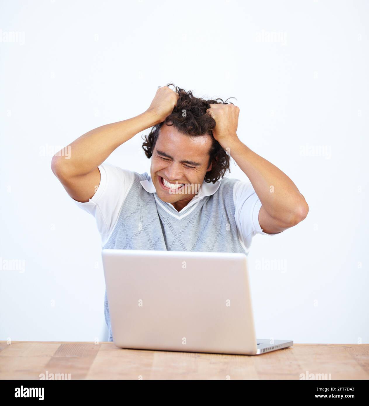 Pulling his hair out in frustration. Frustrated businessman sitting at