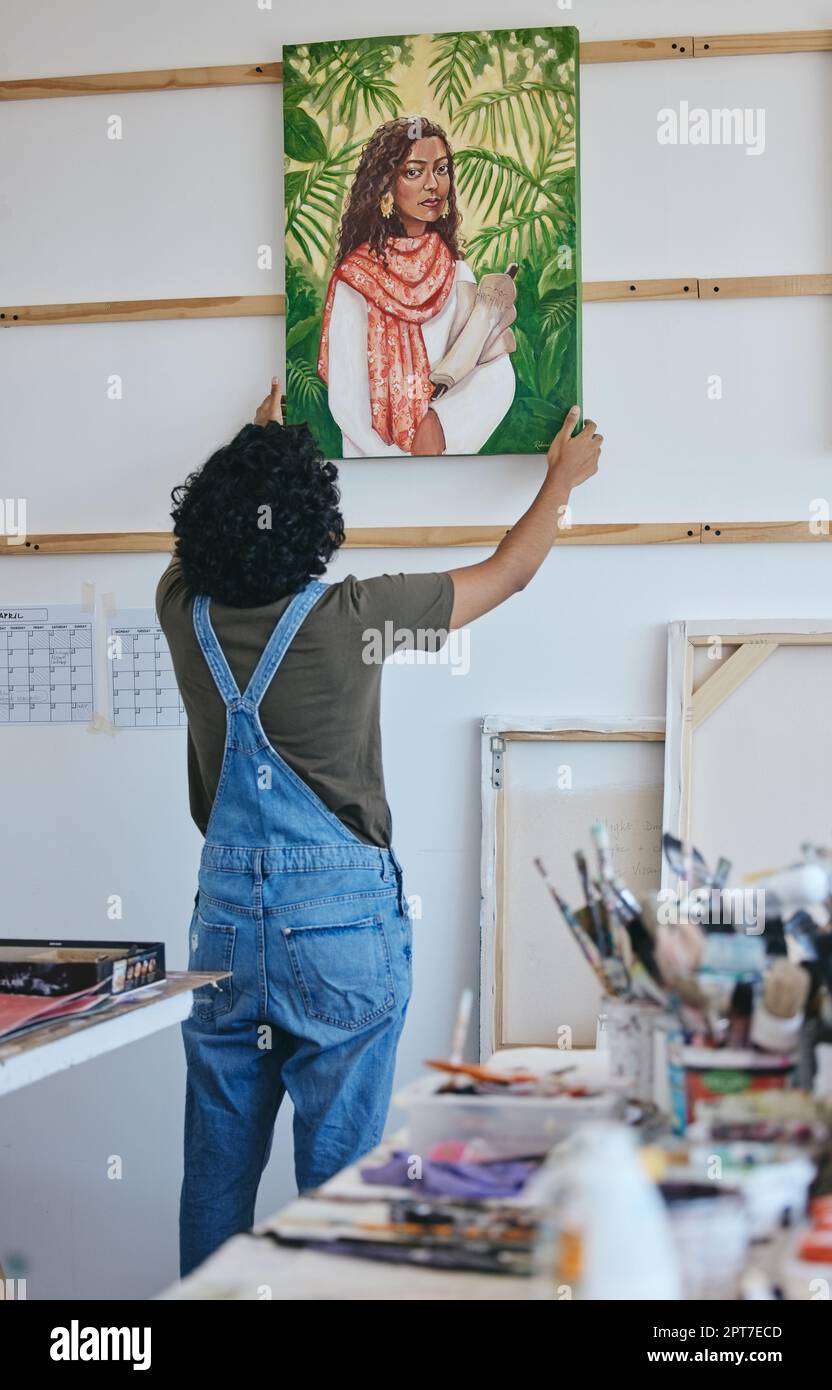 Painter, artist and wall hanging painting in studio to dry before