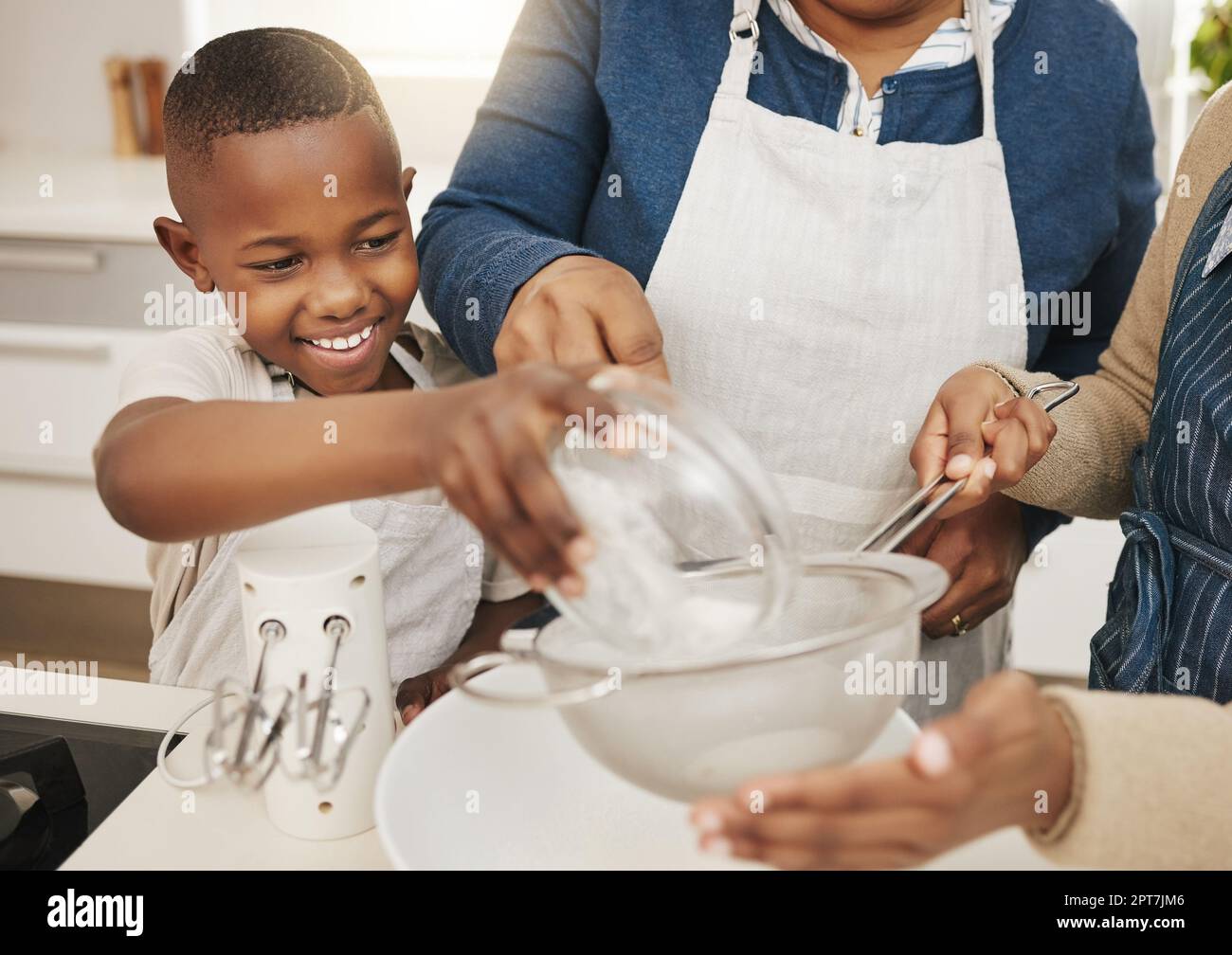 Get all in there. a grandmother baking with her two grandkids at home Stock Photo