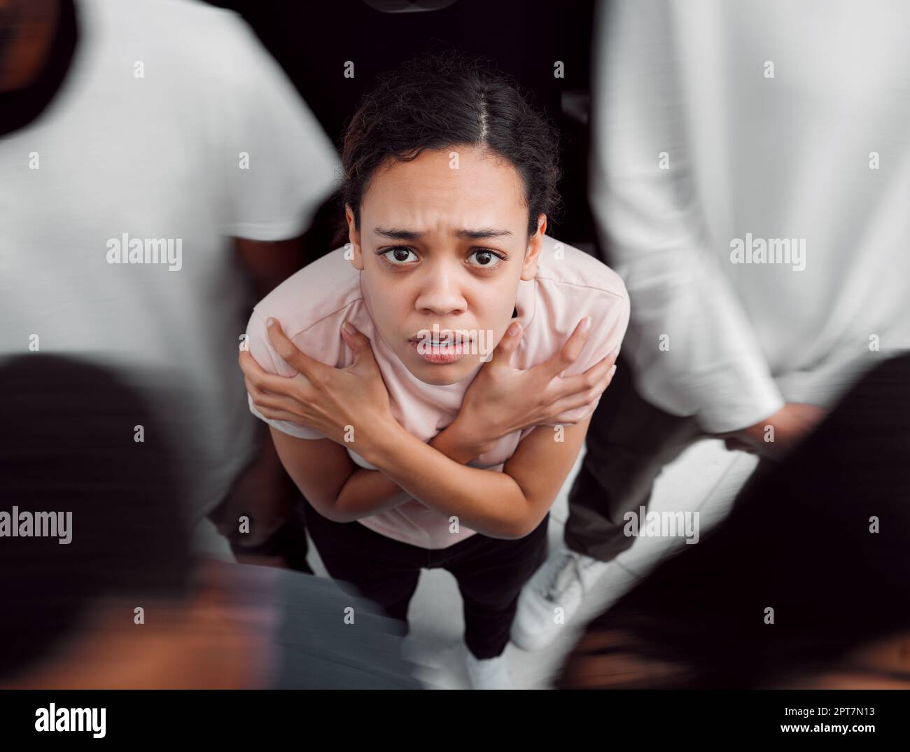 No light that comes on slowly. a young woman experiencing mental illness while being surrounded by people inside Stock Photo