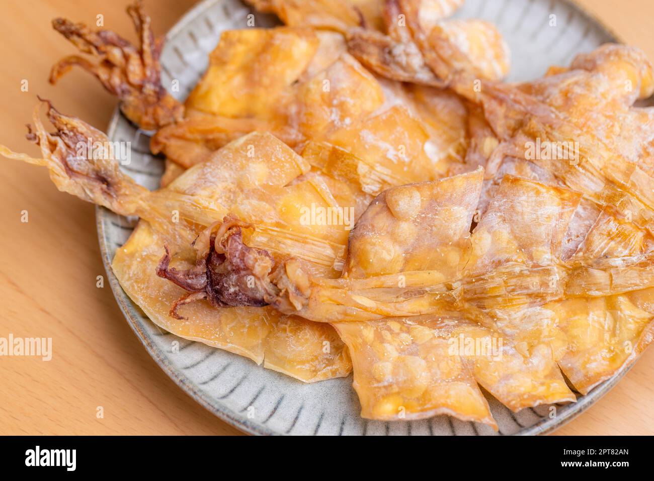 Dried squid snack in the plate Stock Photo - Alamy