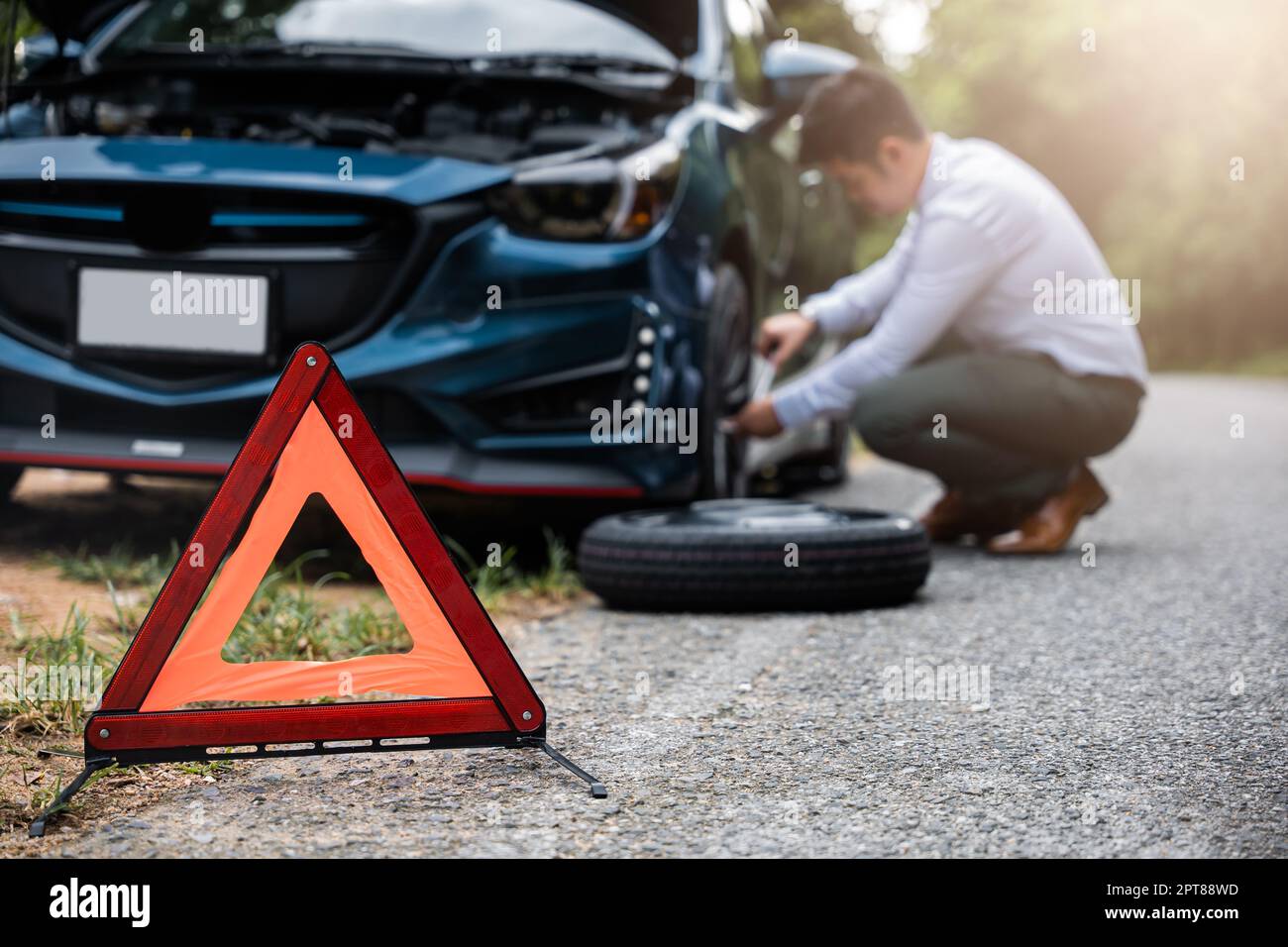 Asian businessman car broken has problems with wheel of his car during