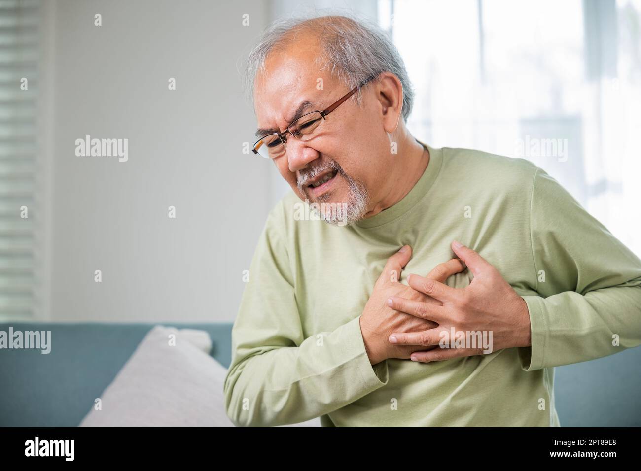 Senior man bad pain hand touching chest having heart attack, Asian older man have congenital disease suffering from heartache alone at home his heart Stock Photo