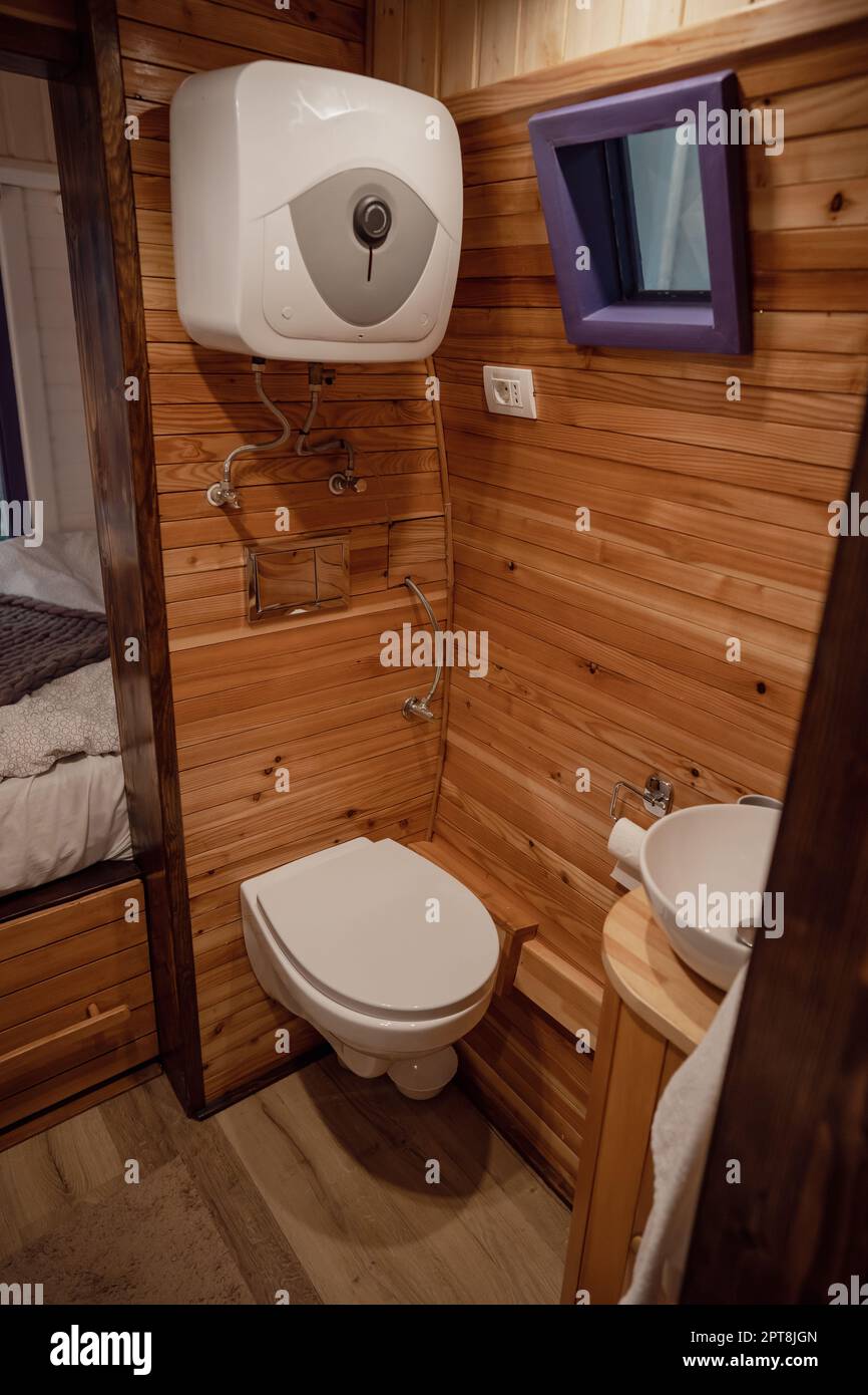 Camper van bathroom interior with toilet, sink and wooden walls Stock