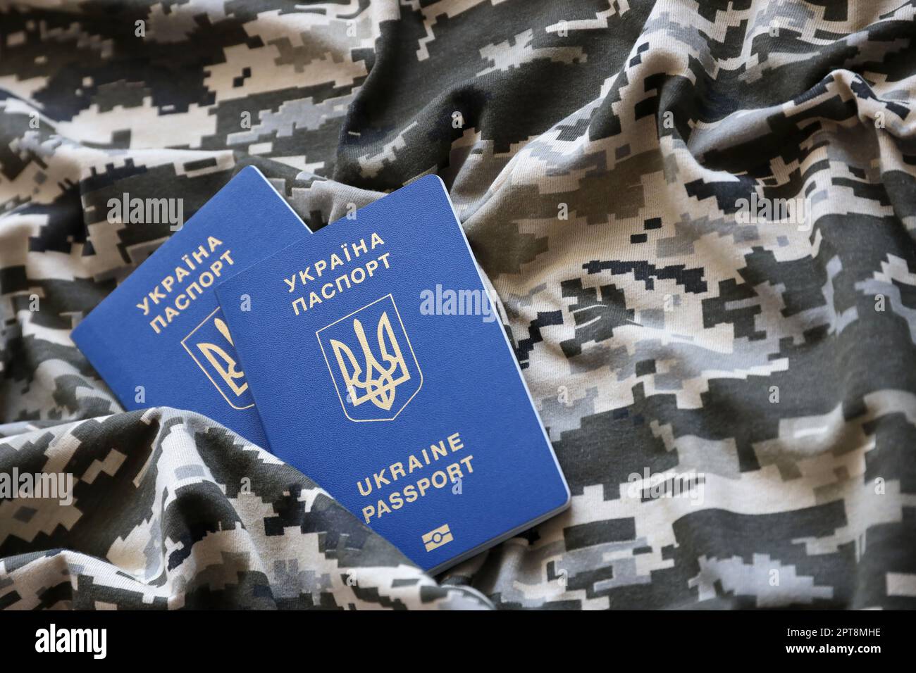 Ukrainian foreign passport on fabric with texture of military pixeled