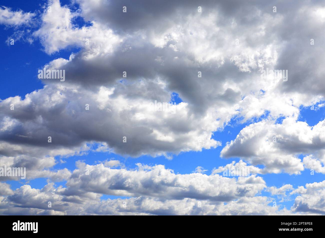 A blue sky with lots of white clouds of different sizes Stock Photo - Alamy