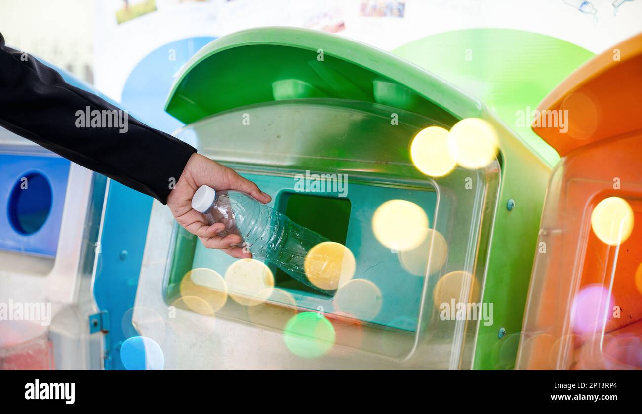 World Environment Day concept. Business woman throwing empty plastic bottle water into recycle garbage trash or bin, Waste management environmental re Stock Photo