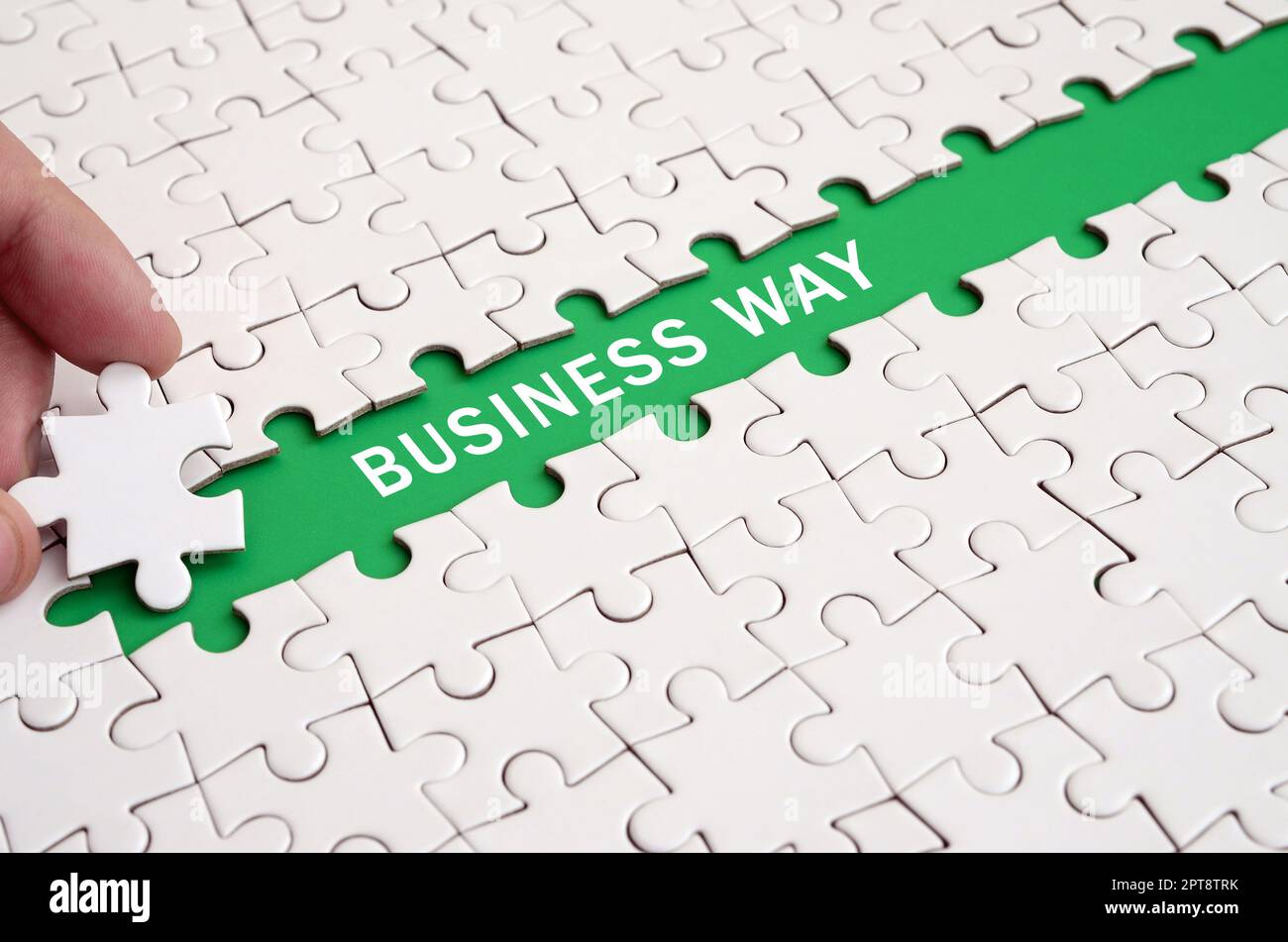 The human hand paves the way to the surface of the jigsaw puzzle The human hand paves the way to the surface of the jigsaw puzzle