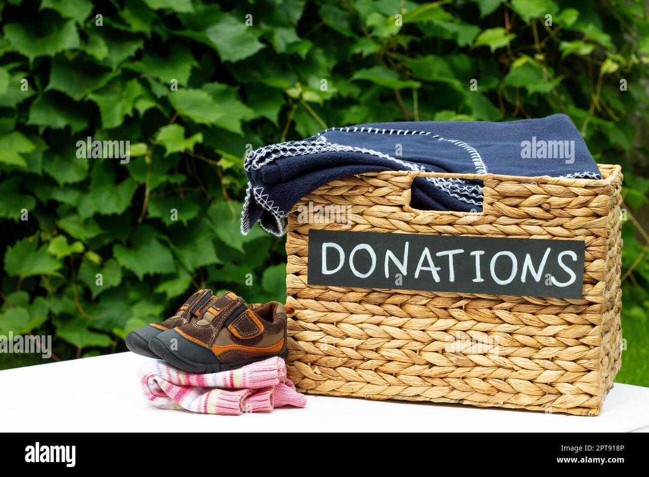 Donation box for clothing donations on a greenery background. Charity