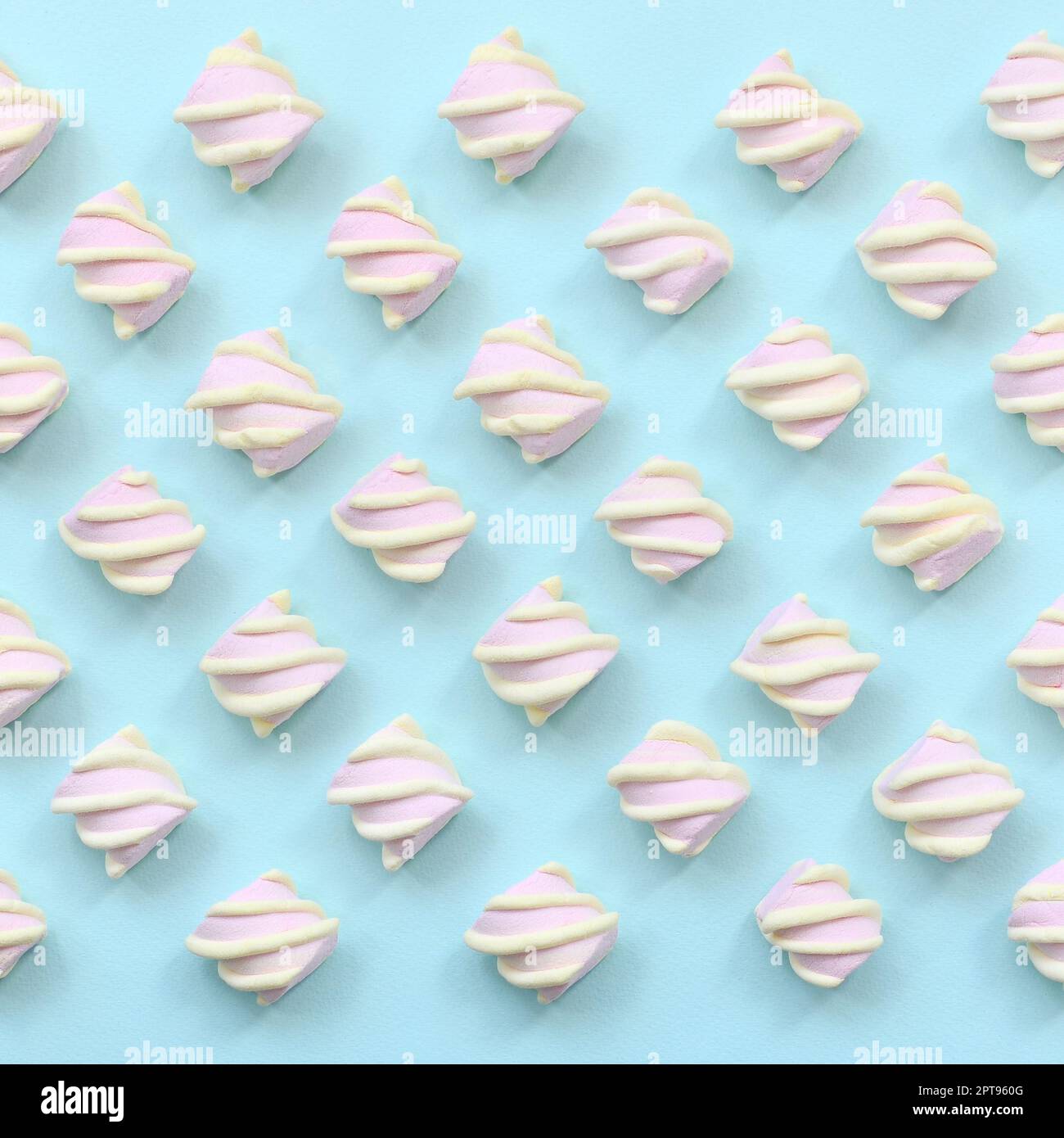 Colorful marshmallow laid out on blue paper background. pastel creative textured pattern. minimal. Stock Photo