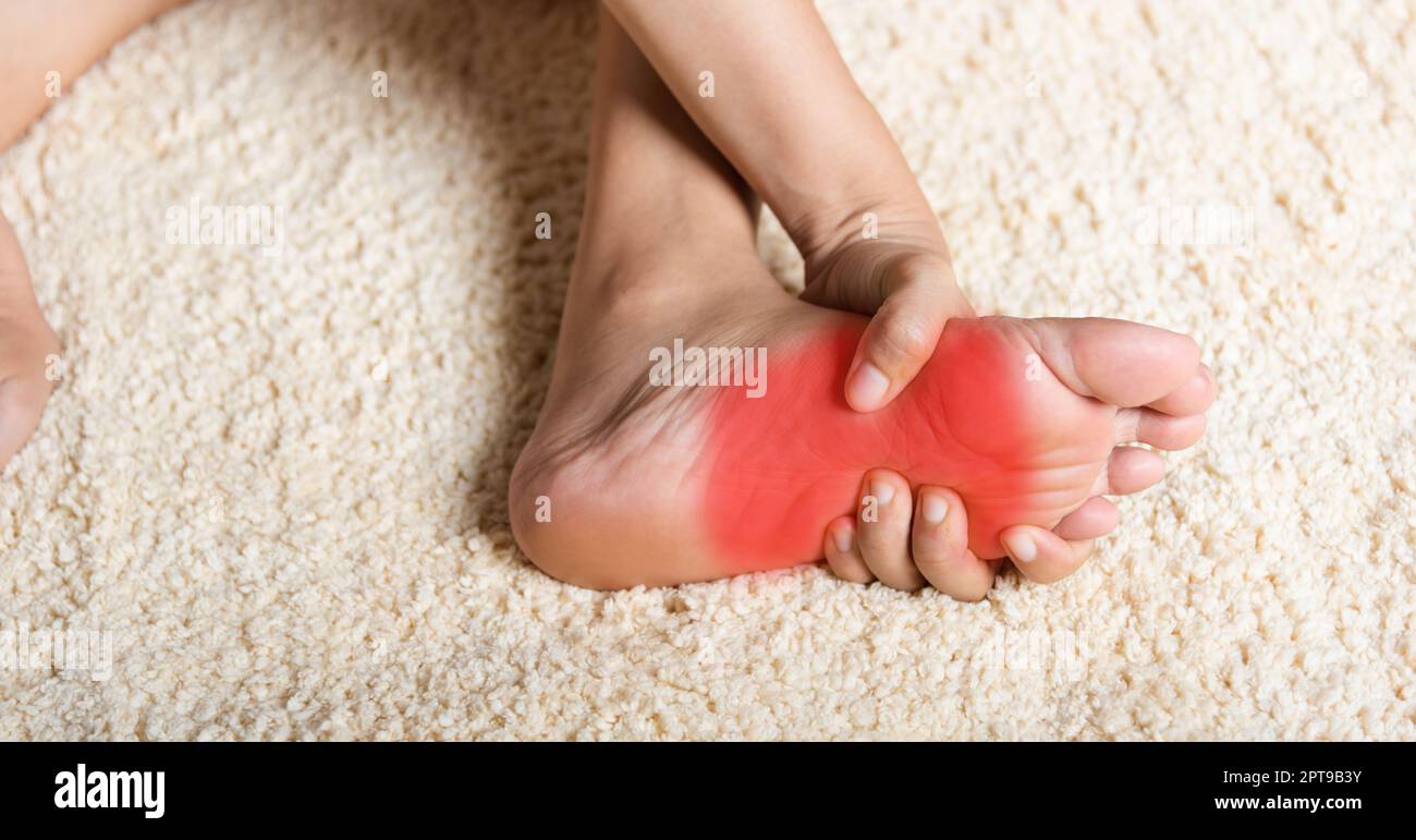 Foot pain, Asian woman feeling pain in her foot at home, female