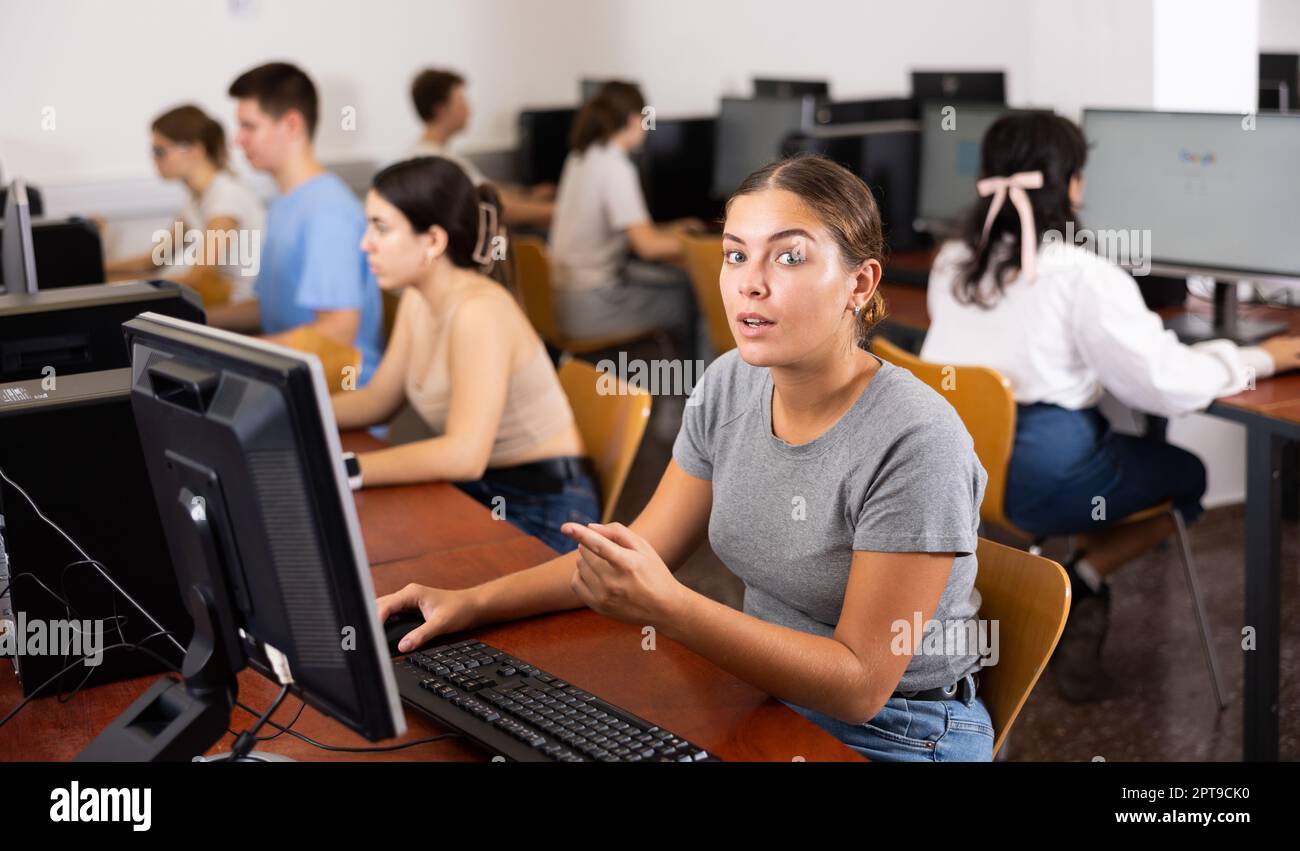 Young woman using computer in classroom, pointing on monitor Stock ...