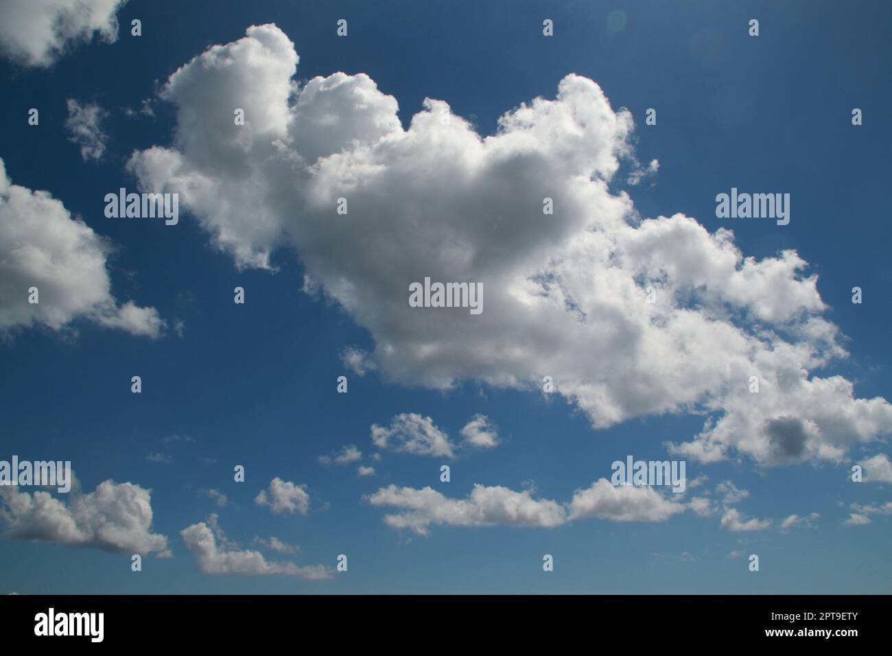 A beautiful blue sky with white clouds and sun rays Stock Photo Alamy