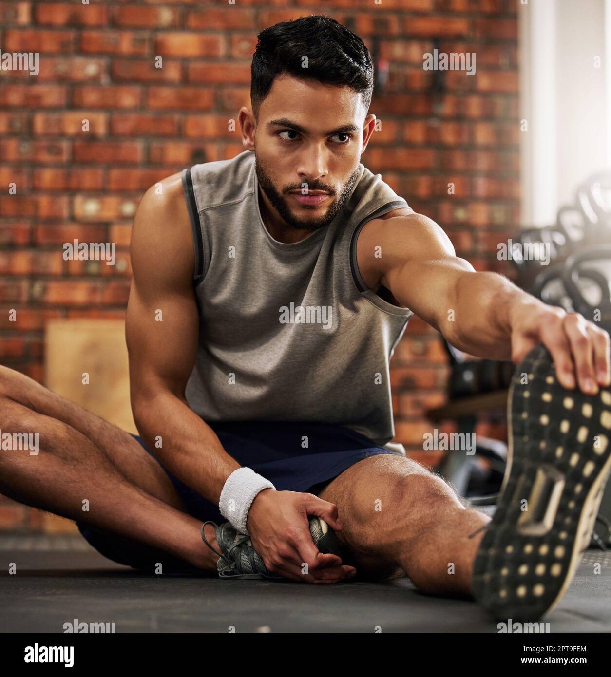 Supple muscles from head to toe. a young man stretching before his ...