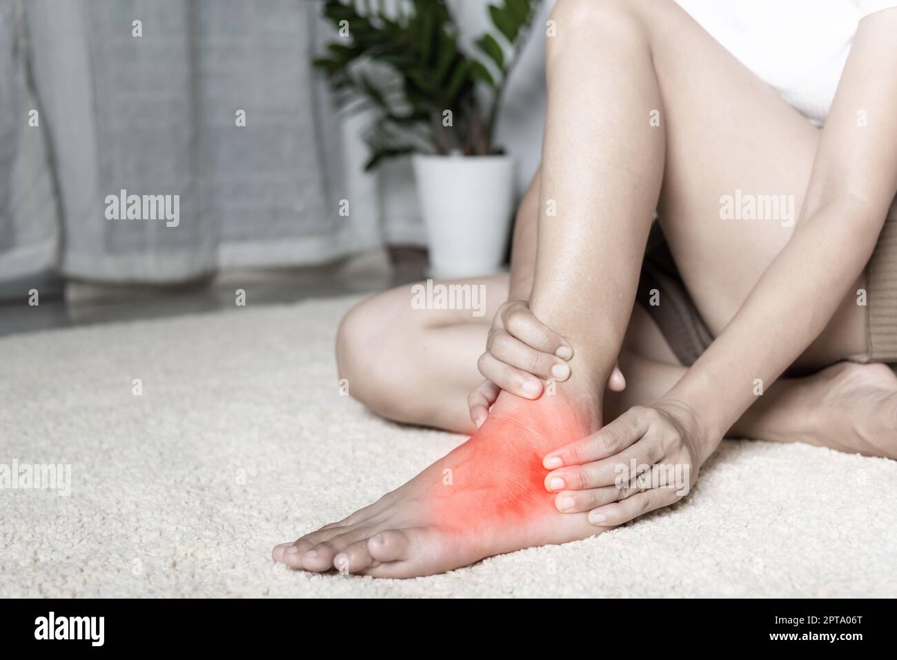 Foot pain, Woman holds her ankle injury feeling pain in her foot at